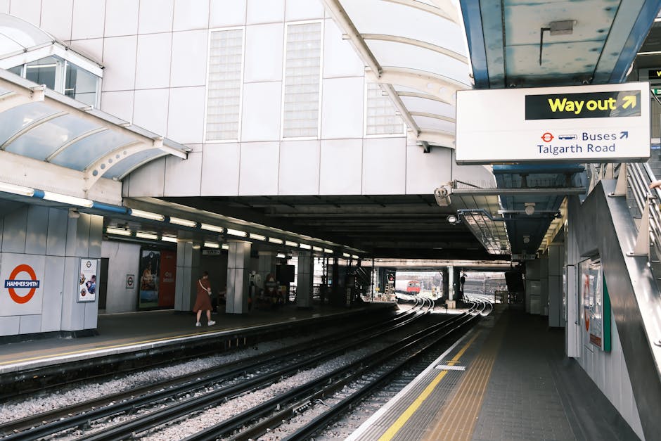 Interior view of Kennington underground station platform with a modern train stopped alongside the tiled platform. The platform features tactile paving strips for accessibility, and the lighting is br